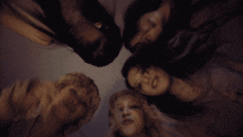 a group of people are laying in a circle and one of them is holding something in her hand