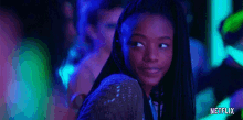 a girl is standing in a dark room with glow in the dark lights .