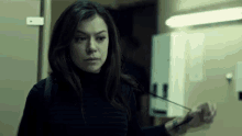 a woman in a black turtleneck is holding a piece of paper