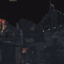 a man wearing a black shirt that says r.i.n.c.p. sits in a dark room
