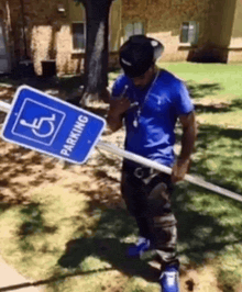 a man is holding a handicapped parking sign on a pole