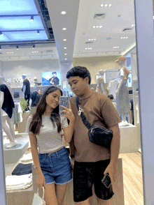 a woman taking a picture of herself and a man in a store