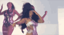 a woman in a purple dress is dancing with another woman in a pink dress .