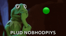 kermit the frog is holding his hand to his face and thinking about a green ball .