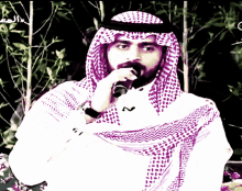 a man with a beard wearing a purple and white scarf holds a microphone