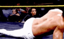a wrestler is laying on the ground in a ring