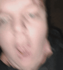 a blurry picture of a man 's face with his mouth open and eyes closed