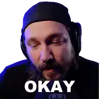 a man with a beard wearing headphones says " okay "