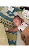 a baby is laying on a bed with a blanket and a pillow