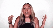 a woman in a black top is making a funny face with her mouth open .