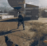 a man in a video game is standing in front of a hot air balloon
