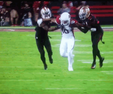 a football player with the number 10 on his jersey is being tackled by another player