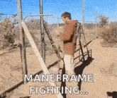 a man is standing in front of a fence with a hose attached to it and says `` maneframe fighting '' .