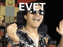 a man wearing sunglasses has the word evet on his face .