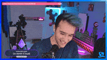a man with green hair is smiling and talking into a microphone while playing a video game