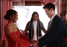 a man and a woman are holding hands during a wedding ceremony in a room .
