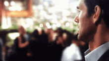 a man in a suit and tie is standing in front of a crowd