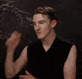 a young man in a black tank top is standing in front of a dragon poster