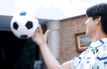 a man is holding a soccer ball in his hand