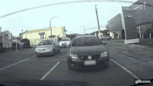 a volkswagen is driving down a street in front of a jaguar land rover dealership