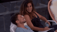 a man and a woman are sitting next to each other on a chair