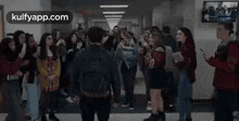 a group of people are standing in a hallway with a man standing in the middle .