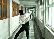 a man in a bloody shirt runs down a hallway