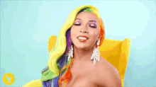 a woman with colorful hair and earrings is sitting in a yellow chair .