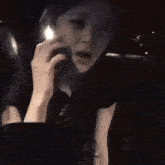 a woman is talking on a cell phone while sitting in a car .