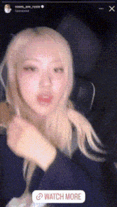 a woman with blonde hair is sitting in a dark room with a watch more sticker