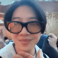 a close up of a person wearing glasses and making a face .