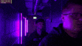 a man and a woman are standing in a hallway with purple lights and a timer that says 00 : 10 : 55