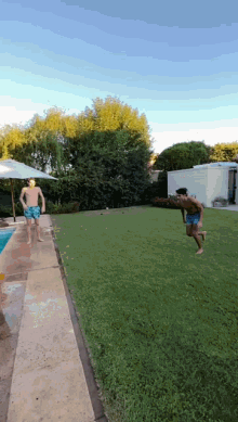 a man in blue shorts is running towards a swimming pool