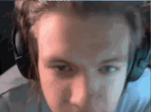 a close up of a person wearing headphones and looking at the camera