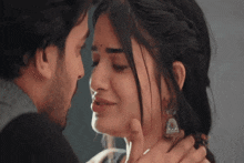 a man and a woman are kissing with their eyes closed and the woman is crying .