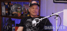 a man sitting in front of a microphone wearing a black shirt that says pel on it