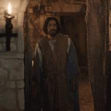 a man with a beard is standing in a cave