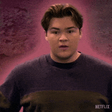a man in a purple shirt with a netflix logo on it