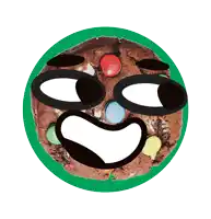 a cookie with a face drawn on it is on a green plate