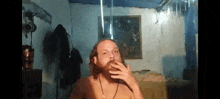 a shirtless man with a beard is smoking a cigarette
