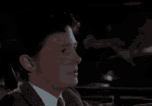 a man and a woman are sitting next to each other drinking wine in a dark room .