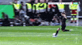 a soccer player kicking a ball on a field with the score 2 to 1