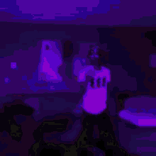 a man is dancing in a room with a green light behind him