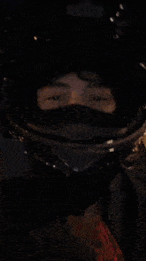 a man wearing a mask and a helmet is walking down a street at night