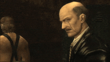 a man wearing an american flag mask is standing next to a bald man in a suit