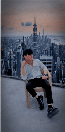 a man sitting in front of a city skyline with a coca cola logo on his shoe