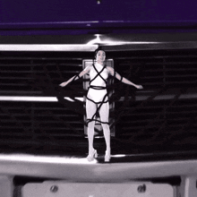 a woman is tied up and standing in front of a purple car