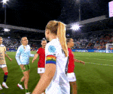 a group of female soccer players on a field with euronics in the back