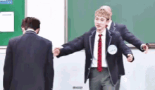 a man in a suit and tie is standing next to another man in a suit and tie .