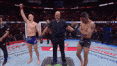 a referee stands between two men in a boxing match